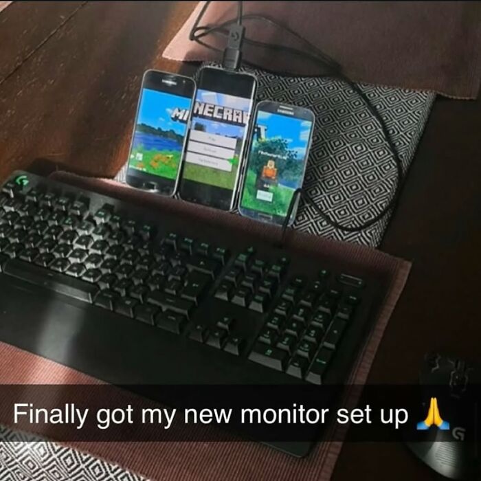 Three smartphones set up as a triple monitor display next to a keyboard in a cursed images style from the IG page.