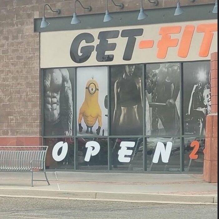 Gym window display with muscular figures and a funny cursed image of a minion with a muscular body disturbing fans online.
