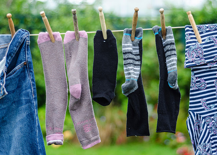 Socks and clothes hanging on a line outside, illustrating common family habits and routines people assume everyone does.