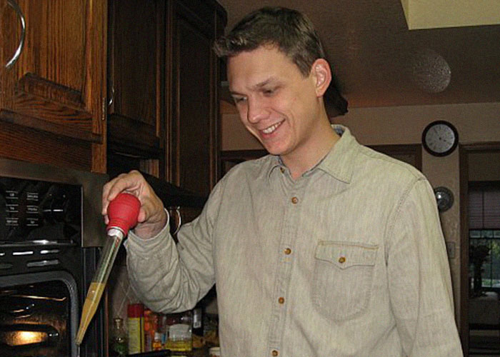 Man using a dropper in a kitchen, illustrating people assumed everyone did these family routines and habits.