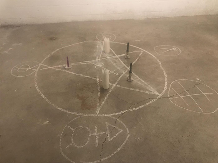 Chalk-drawn pentagram with candles placed at points on a concrete floor, revealing a surprising side of kids.