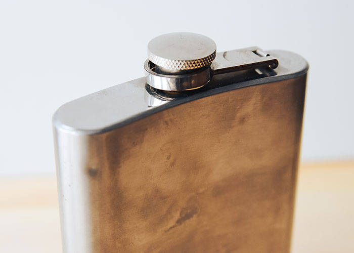 Close-up of a metal flask symbolizing the madness some people had to witness at work deserving bonuses.