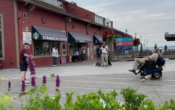 Outdoor scene near Starbucks coffee shop with a man in a wheelchair, highlighting a white man shoots black disabled veteran incident. Outdoor scene near Starbucks coffee shop with a man in a wheelchair, highlighting a white man shoots black disabled veteran incident.