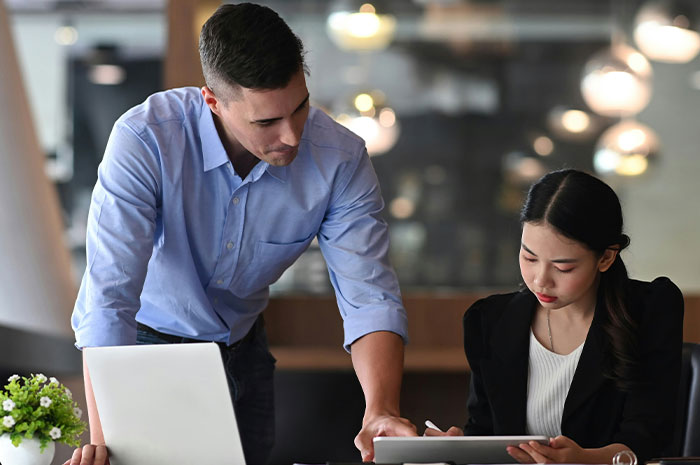 Boss gives formal reprimand to employee in office after she misses a meeting for being off-duty.