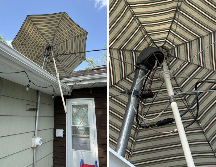 Striped patio umbrella caught in unusual position above a house, showcasing Mother Nature doing things on its own terms.