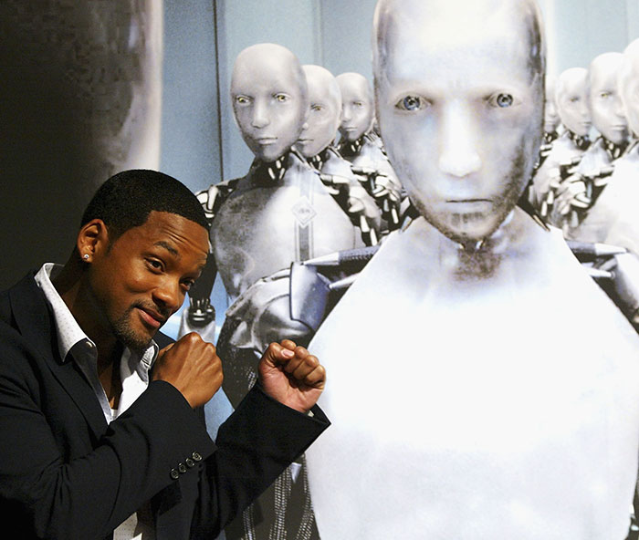 Will Smith posing with robot characters, highlighting a co-actor accusing studio of removing his name from publicity.