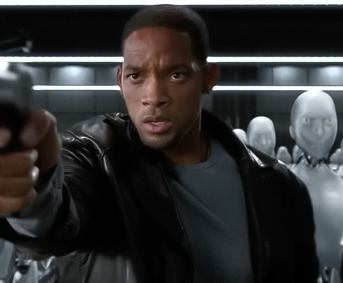 Will Smith aiming a gun in a scene with robots in the background, related to co-actor publicity removal claim.