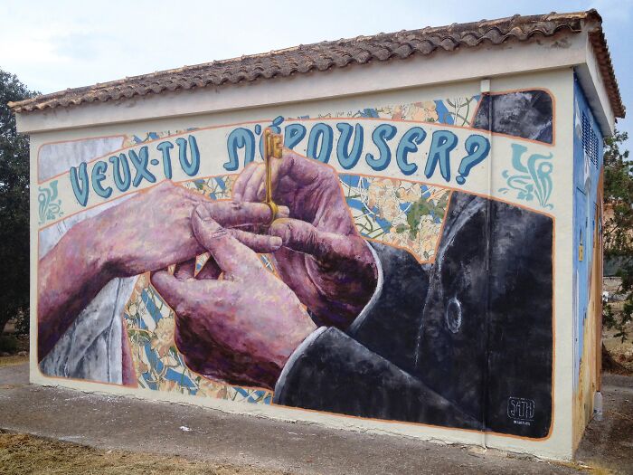 Street art mural on building showing hands holding a key with text, showcasing creative street art photos as urban canvas.