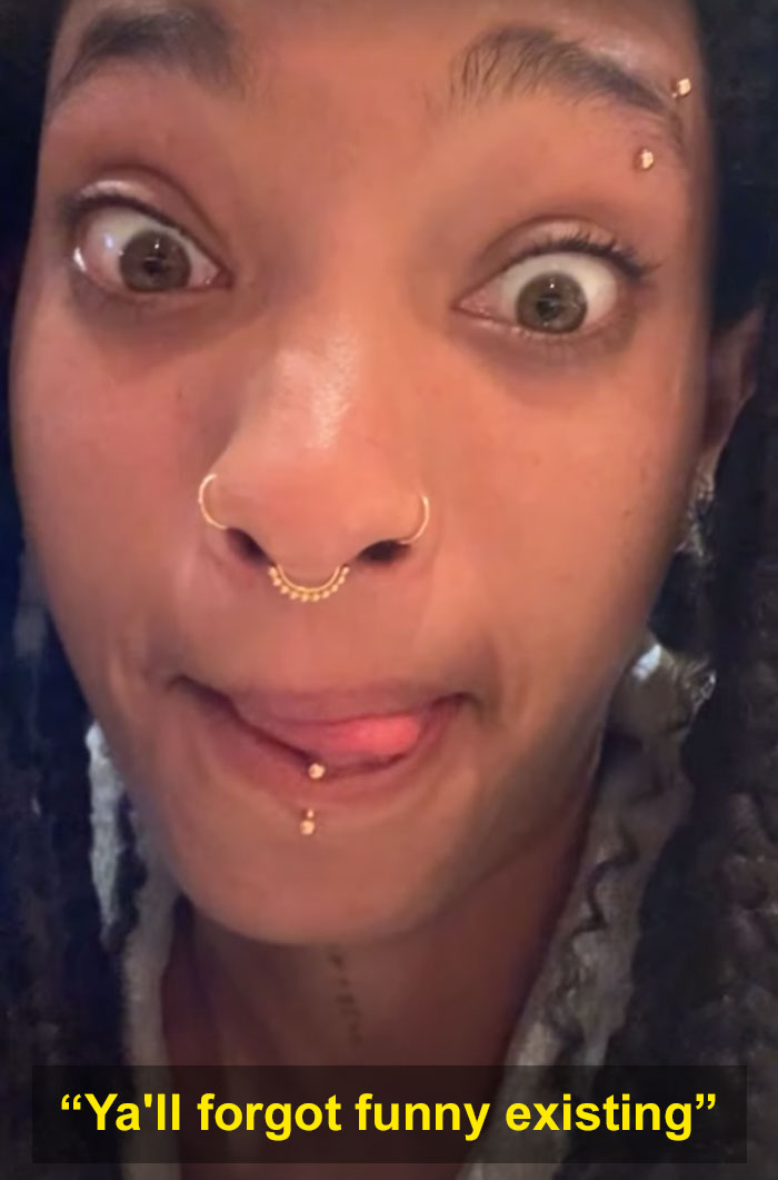Close-up of a young woman with facial piercings making a playful face, sparking worries after crying selfie message.