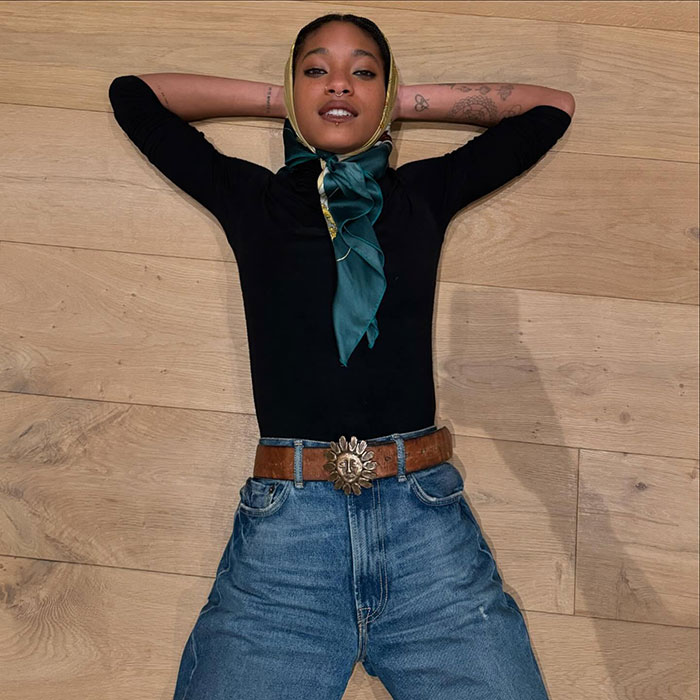 Will Smith and Jada Pinkett's daughter lying on wooden floor wearing a headscarf and casual outfit
