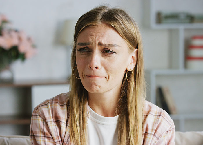 Young woman with tearful expression reflecting heartbreak after parents lose interest when she moves out Young woman with tearful expression reflecting heartbreak after parents lose interest when she moves out