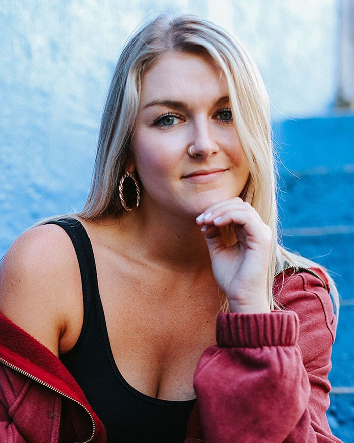 Young woman wearing hoop earrings and a red jacket, highlighting smart ring detecting major illness before diagnosis.