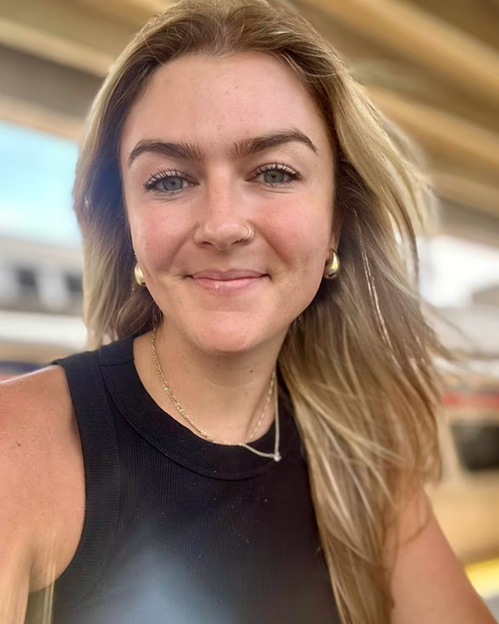 Young woman smiling outdoors, illustrating smart ring detecting major illness months before doctor's diagnosis.