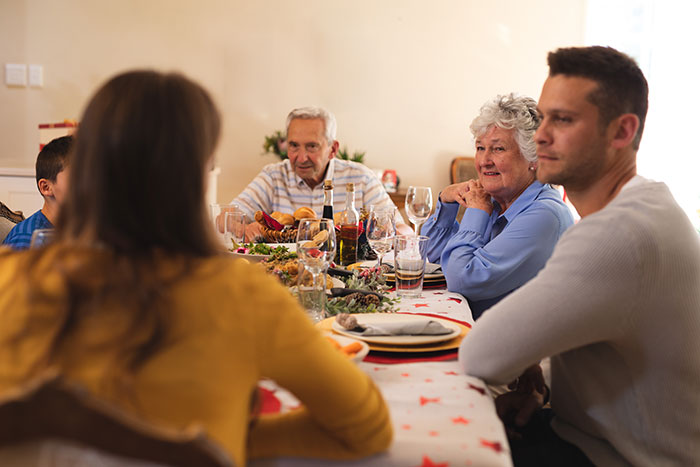 Working mom having a tense conversation with in-laws at a family dinner, addressing daycare challenges and work-life balance. - 12