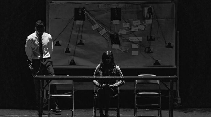 Two people in a dimly lit room with a whiteboard and diagram, creating a tense atmosphere for a would you rather poll.