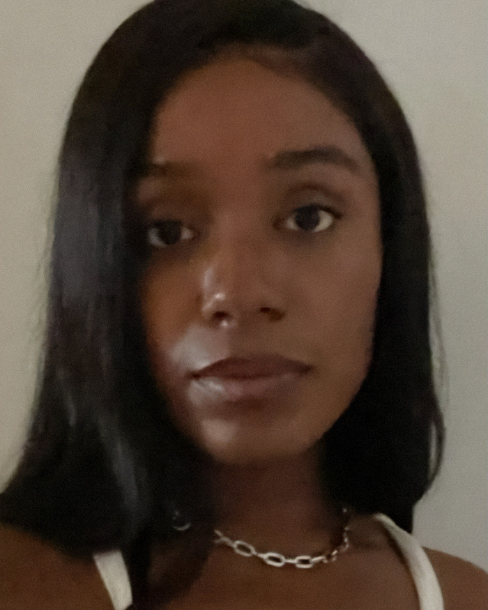 Close-up of a woman with long dark hair and a chain necklace, related to writer hit with karma after posts resurface.