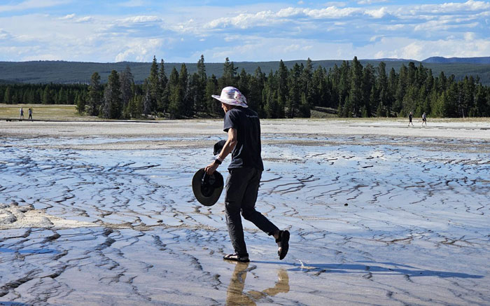 Visitor walking across forbidden area in Yellowstone, raising concerns about where the rangers are in the park. - 2