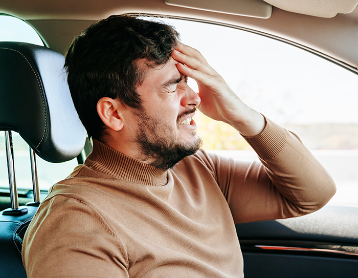 Man sitting in car looking frustrated, refusing to check restaurant&rsquo;s menu while wife decides not to eat out