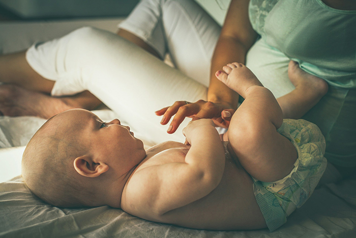 Woman caring for baby lying on bed, symbolizing sacrifice and challenges in woman's marriage and life decisions. Woman caring for baby lying on bed, symbolizing sacrifice and challenges in woman's marriage and life decisions.
