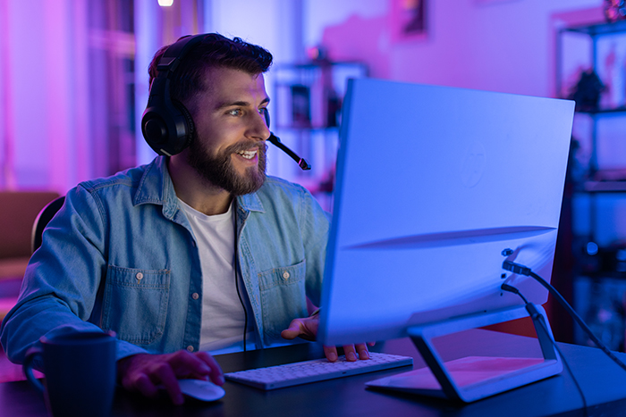 Man with headset gaming in colorful man cave setting, representing husband refusing to work or help out.