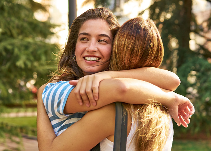 Two women hugging outdoors, illustrating a bride asking if she’s wrong for refusing SIL’s service dog at her wedding. Two women hugging outdoors, illustrating a bride asking if she’s wrong for refusing SIL’s service dog at her wedding.
