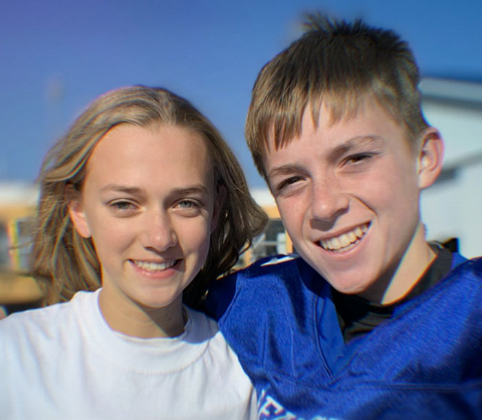 Teen girl and boyfriend smiling outdoors, representing victims tormented by a sick catfish and obsessed mom.