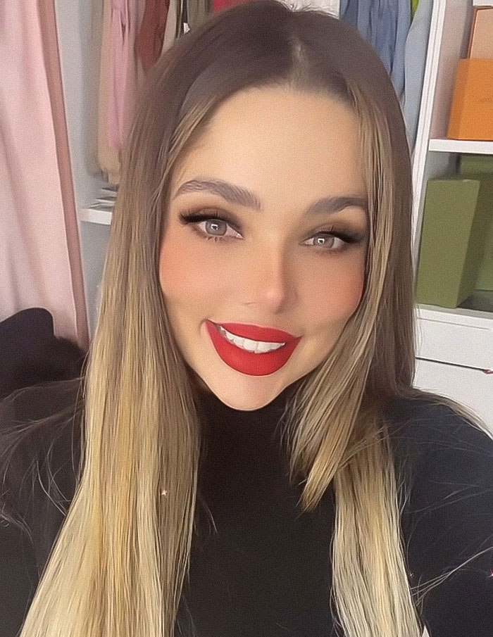 Influencer Esmeralda Ferrer Garibay smiling with long hair and red lipstick in an indoor setting with shelves behind her Influencer Esmeralda Ferrer Garibay smiling with long hair and red lipstick in an indoor setting with shelves behind her