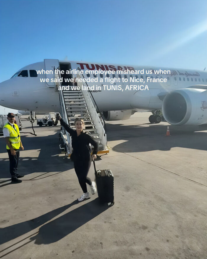 Tourist with luggage on tarmac near plane, highlighting confused tourists boarding flight to Africa instead of France.