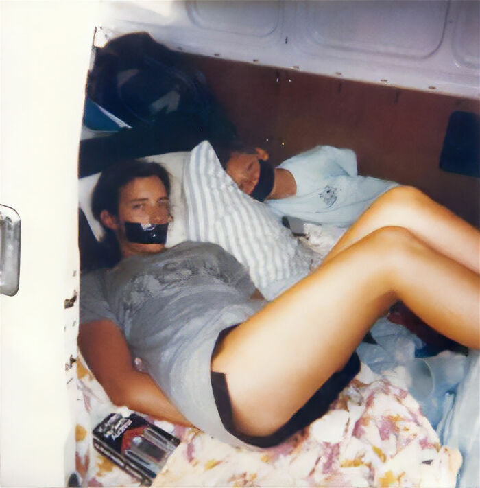 Two people lying inside a confined space with tape over their mouths in a strange and unexplained histories photo.