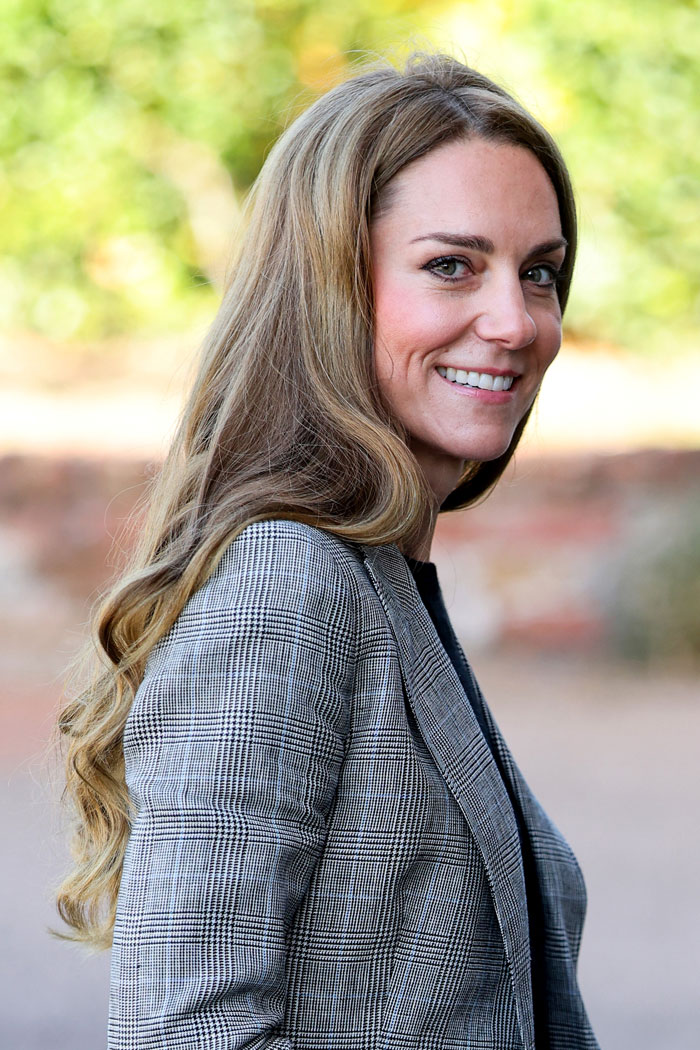 Woman with long hair smiling outdoors, demonstrating the no-hairband perfect bun trick for viral hair styling. Woman with long hair smiling outdoors, demonstrating the no-hairband perfect bun trick for viral hair styling.