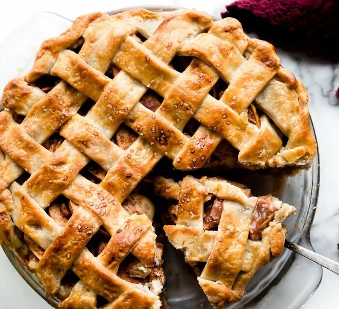 Close-up of a homemade lattice-top pie with a slice being served, highlighting a food-shaming moment between mom and daughter.