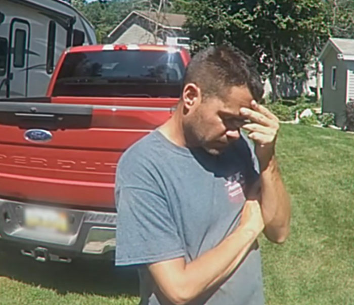 Man in casual shirt standing outside near red truck, appearing stressed by teen girl and boyfriend catfish torment ordeal.