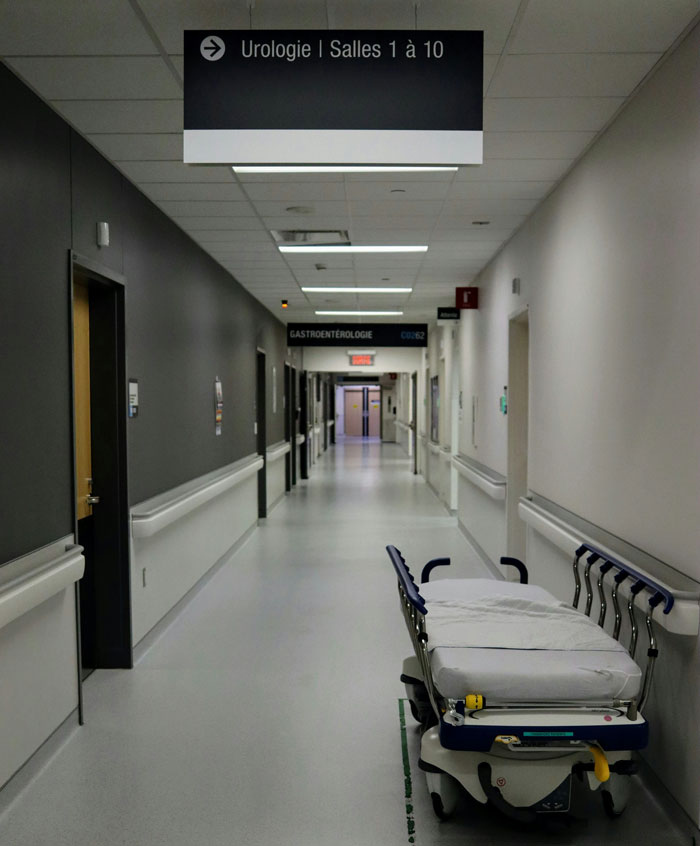 Empty hospital corridor with a medical stretcher, illustrating a creepy setting for security guards on the job.