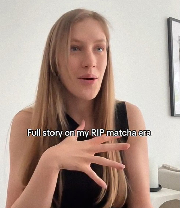 Woman speaking indoors with long hair, sharing a public warning over matcha after hospitalizing a 28-year-old.