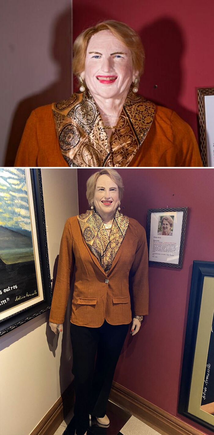Wax sculpture of a famous figure with a patterned scarf and orange blazer, showcasing creepy and hilarious artistic style.