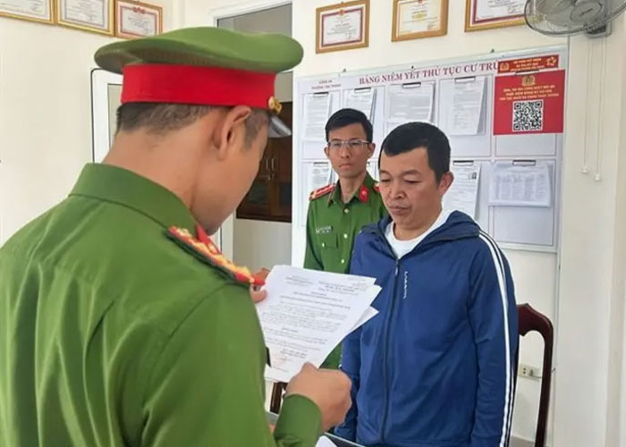 Police officers presenting documents to a man in a blue jacket during investigation of poisoned limoncello case.