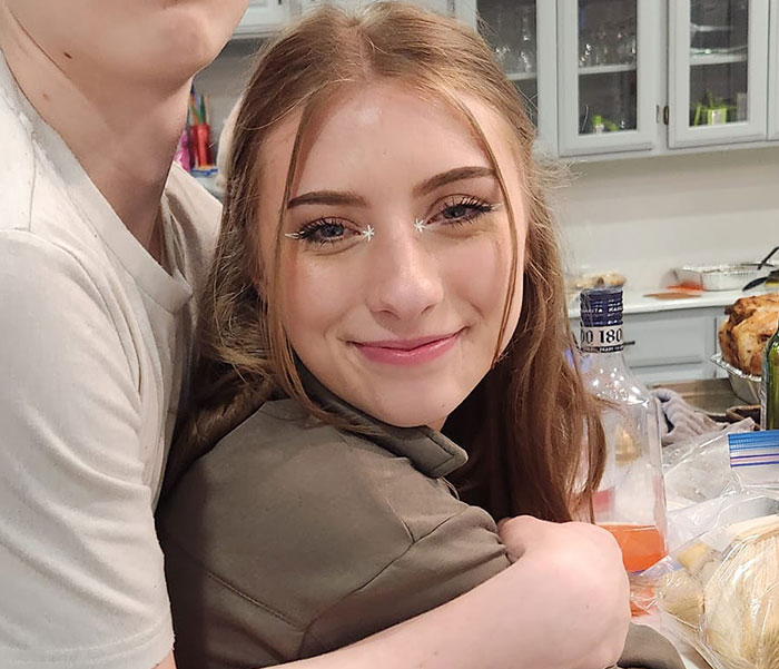 Two sisters hugging in a kitchen setting, related to sisters who destroyed Charlie Kirk memorial and became homeless.