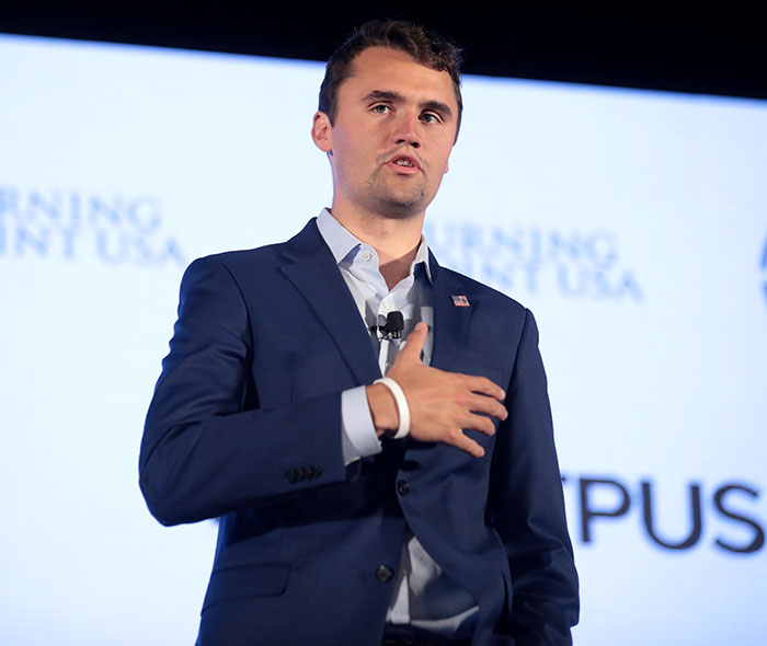 Young man speaking on stage at a conference, with a focus on Elon Musk accused of hypocrisy in the viral church message.