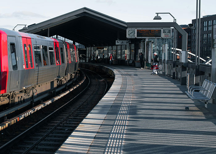 Train arriving at an empty station platform with a few people waiting, illustrating incredible coincidences.