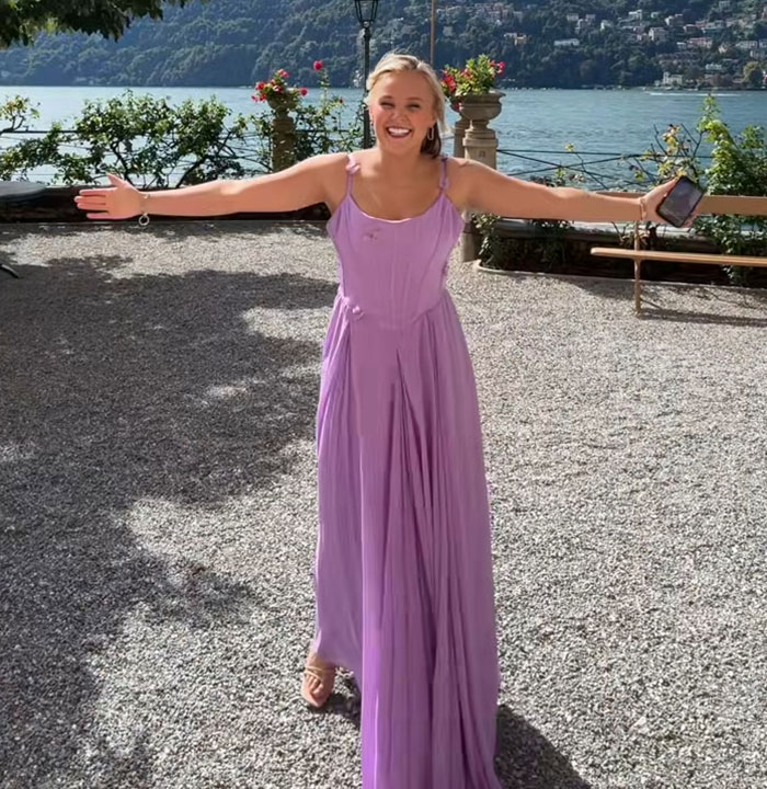 JoJo Siwa smiling outdoors in a purple dress, embracing fans after sharing her marriage plans and gold mini dress look.