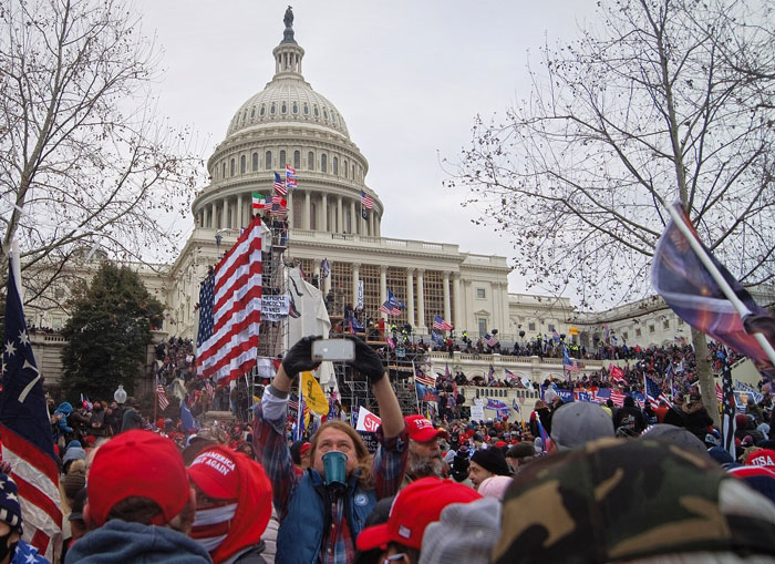 Crowd at the Capitol with flags and signs illustrating a complete collapse of common sense during a chaotic event.