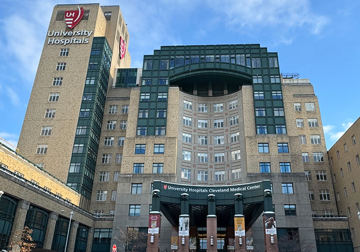 University Hospitals Cleveland Medical Center building under blue sky, related to cop opens fire and self-defense debate.