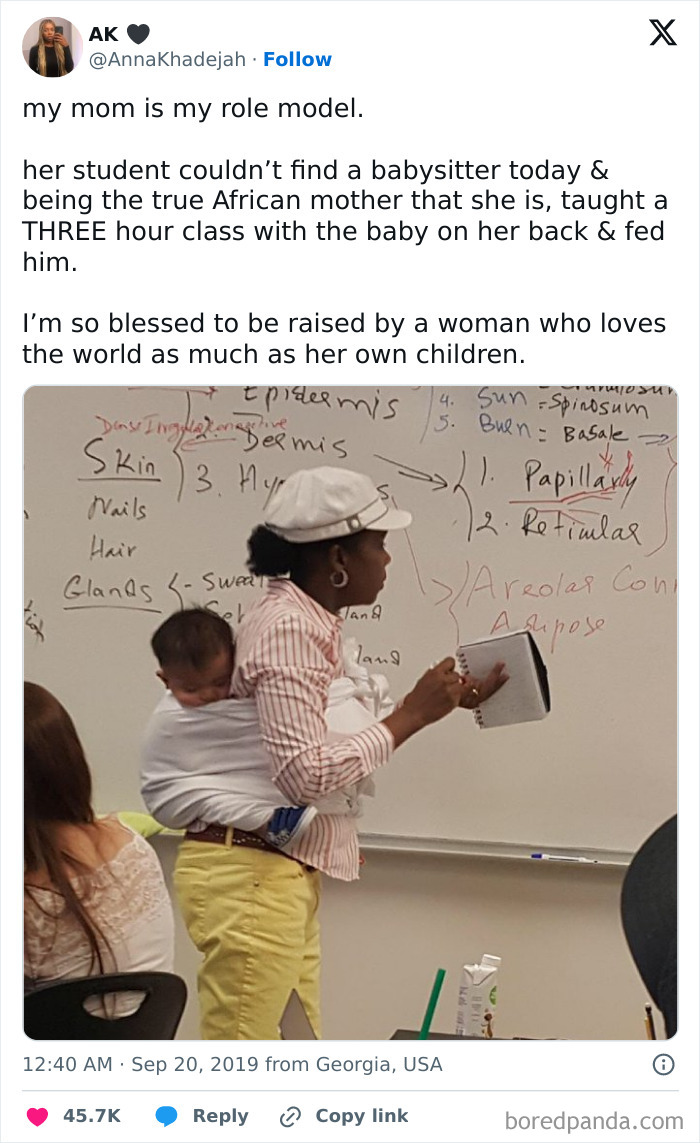 African mother teaching a class with baby on her back, showcasing amazing and wholesome mom moments.