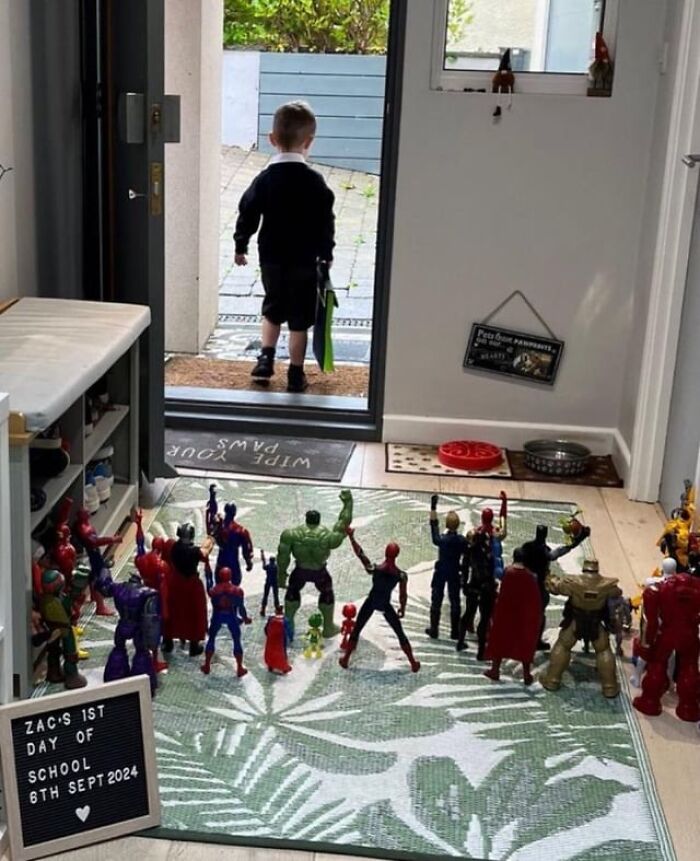 Child’s first day of school celebrated with superhero toys arranged on a rug, creating a wholesome and heartwarming scene.