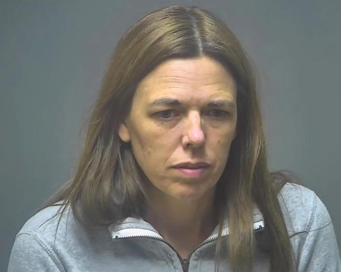 Woman with long brown hair wearing a gray zip-up top, related to story about obsessed mom catfish tormenting teen girl and boyfriend.