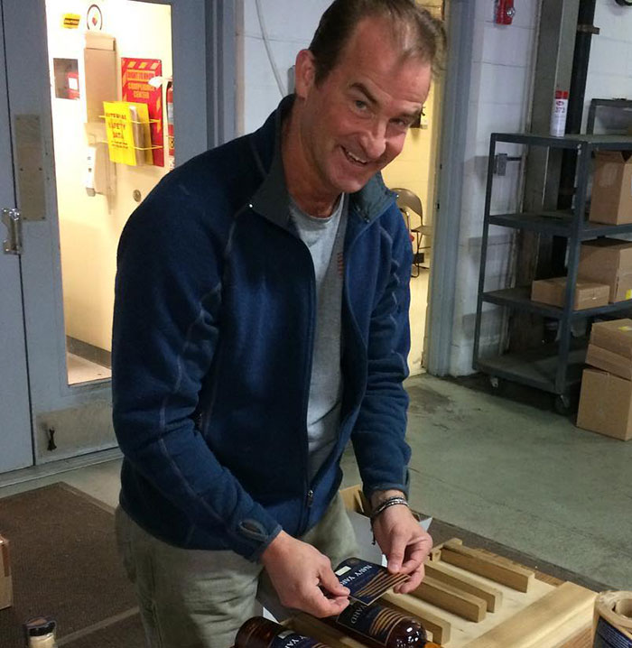 Middle-aged man in casual clothing preparing bottles, representing husband of woman caught with CEO amid divorce news. Middle-aged man in casual clothing preparing bottles, representing husband of woman caught with CEO amid divorce news.