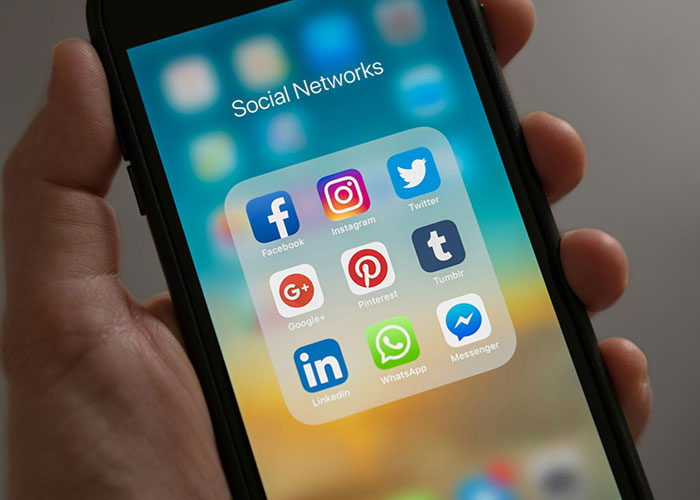 Smartphone screen showing social networks apps, illustrating historical events impact on society through social media usage.