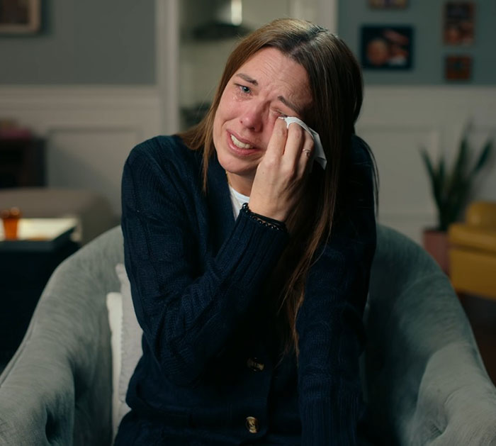 Woman crying and wiping tears, reflecting distress related to teen girl and boyfriend tormented by obsessed mom catfish incident.