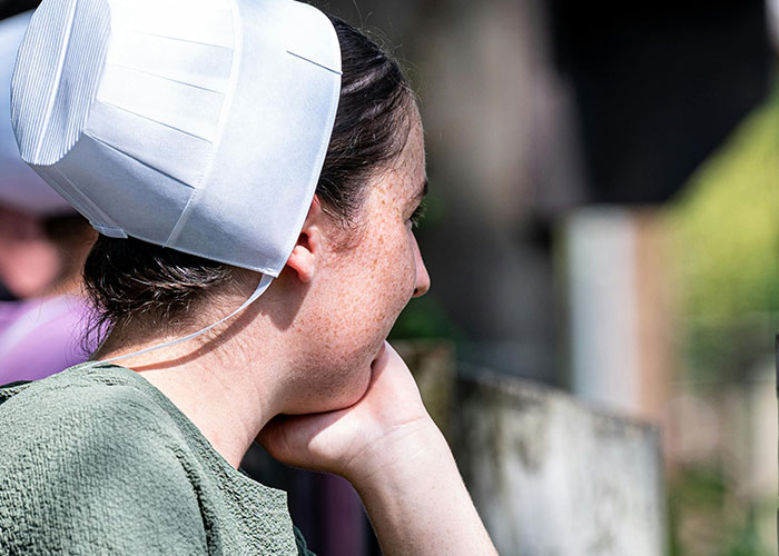 Young woman in traditional clothing resting her head on her hand, captured in a candid moment related to criminal fails humor.