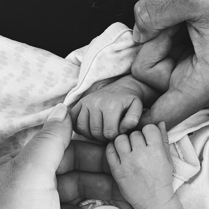 Hands holding baby feet in a tender moment, symbolizing connection and care in Charlie Kirk's wife haunting post context.